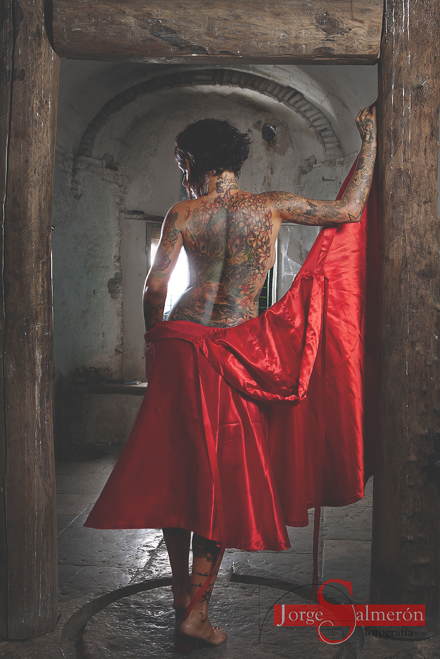 Mujer muy tatuada con capa roja