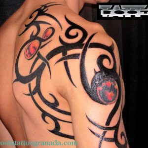 Tatuaje tribal bolas color hombro y espalda hombre