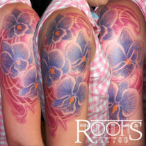 Tatuaje flores moradas medio brazo mujer