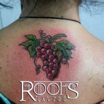 Tatuaje de racimo de uvas moradas con hojas de parra