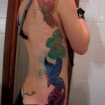 Tatuaje mariposas de color costado chica sexy, Roots Tattoo Granada