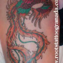 Tatuaje fenix muslo chica, colores vivos plumas largas